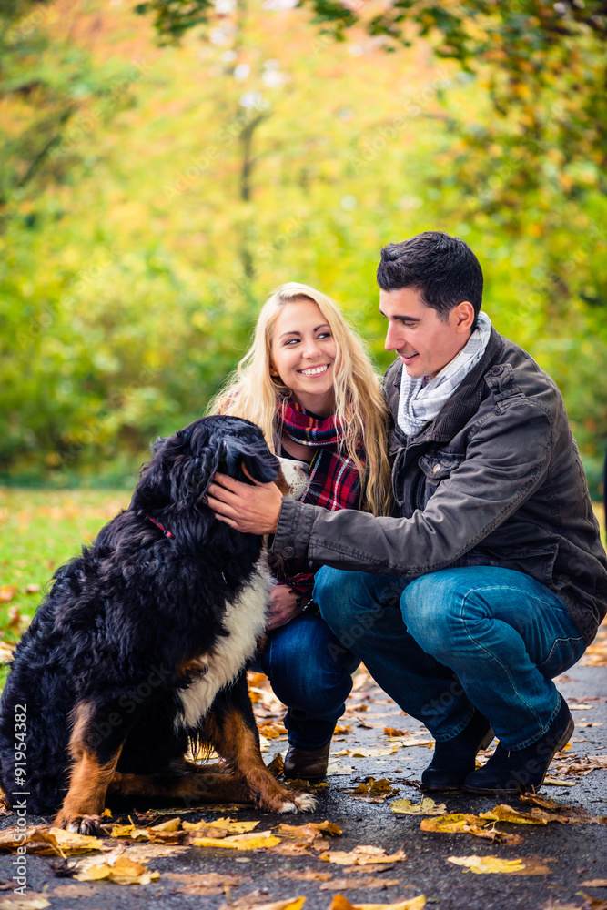 Paar mit Hund genießt den Herbst in der Natur