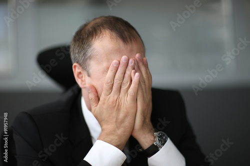 Failure in business, man hiding his face with hands photo