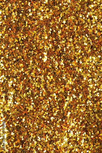 Gold sand and dust texture. Golden sparkling glitter background. Metallic surface. 