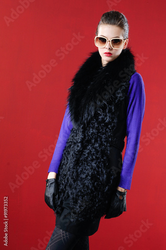 Fashion girl wearing sunglasses posing in studio