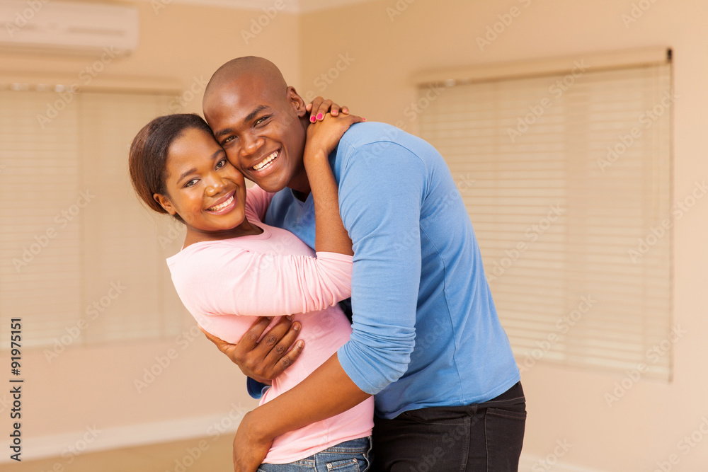 young african couple hugging in empty house young african couple hugging in empty house