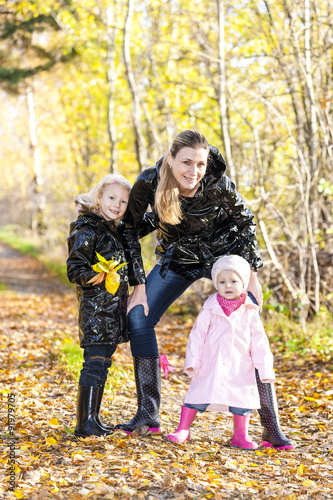 mother with her daughters in autumnal nature