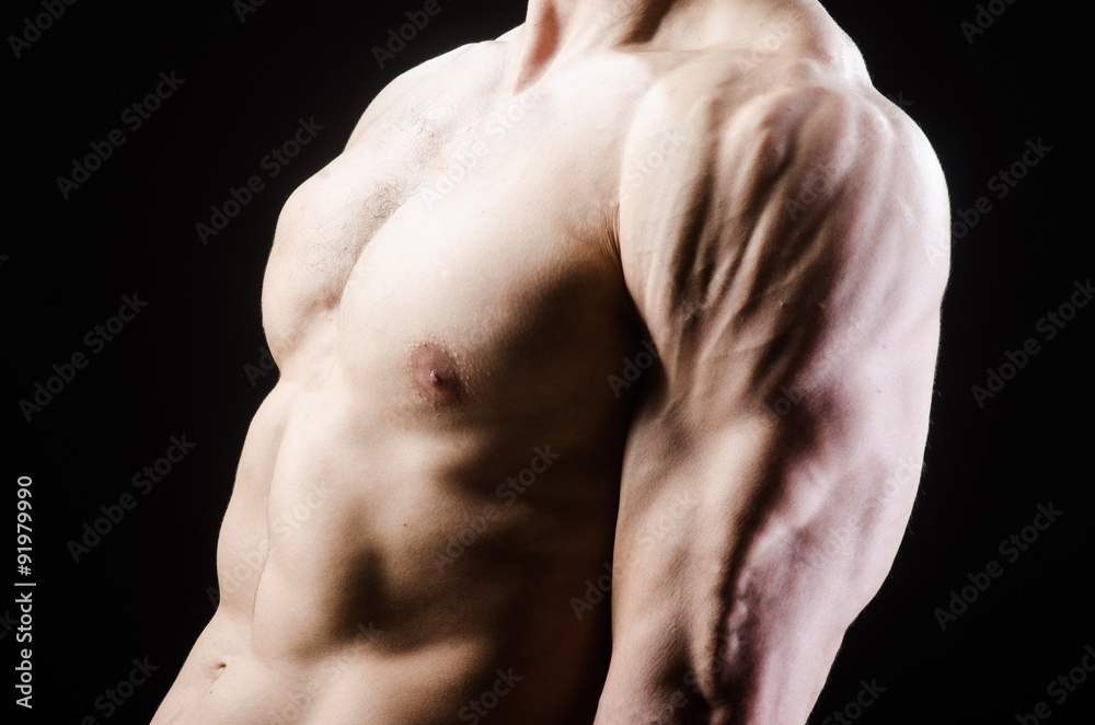 Muscular man posing in dark studio Muscular man posing in dark studio
