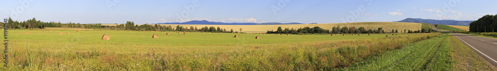 Beautiful panorama the sloping fields and haystacks.