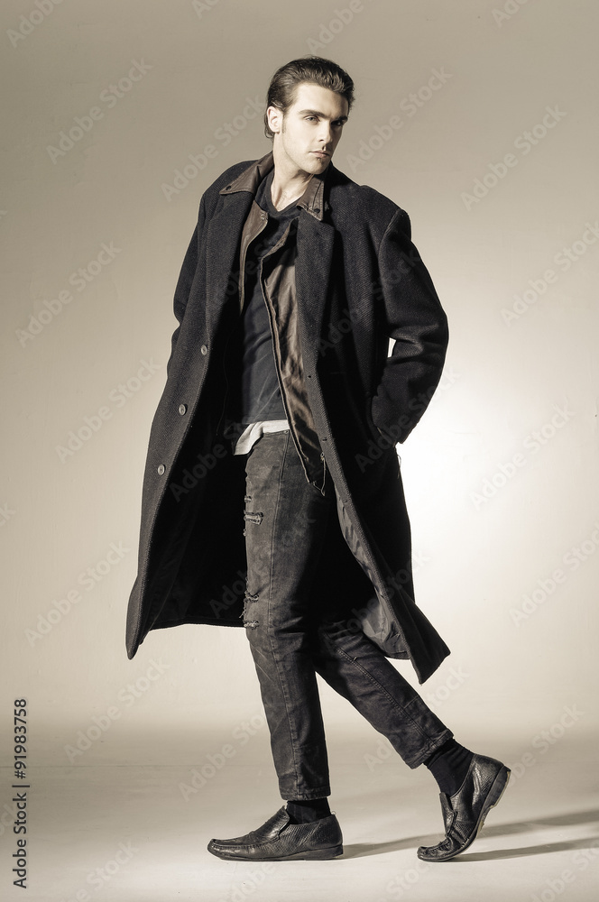 Full body portrait of a young fashion male walking on light background Full body portrait of a young fashion male walking on light background