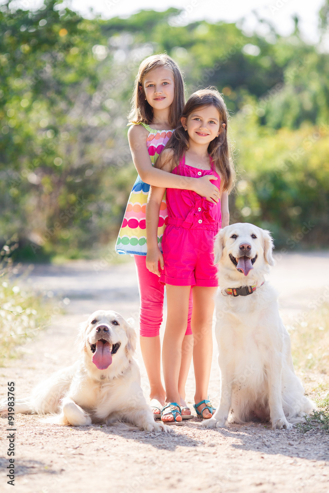 Two sisters on a walk with the dogs in the park Two sisters on a walk with the dogs in the park