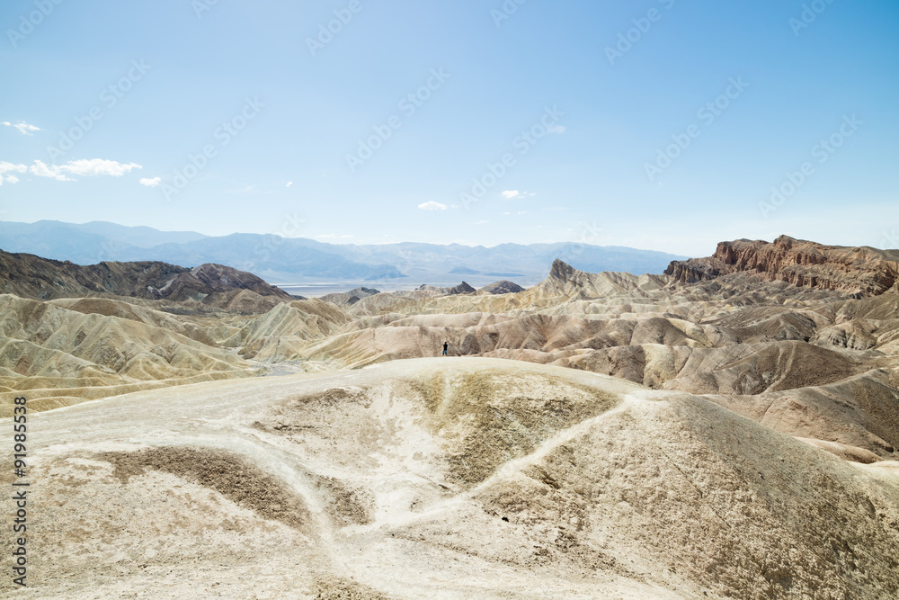 Man overlooking dry and arid sand dune landscape in Death Valley National Park Man overlooking dry and arid sand dune landscape in Death Valley National Park