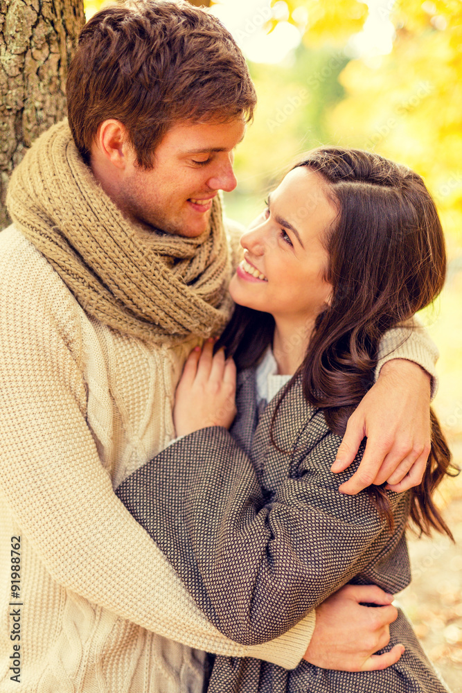 Fototapeta premium smiling couple hugging in autumn park