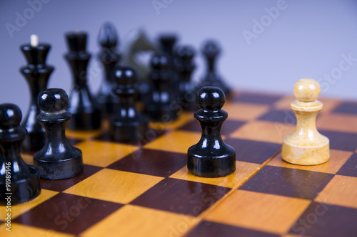 Concept with chess pieces on a wooden chess board