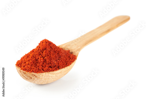 Paprika on a wooden spoon isolated on white background