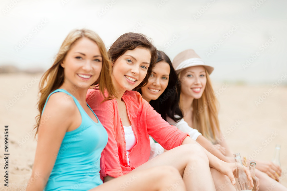 smiling girls with drinks on the beach smiling girls with drinks on the beach