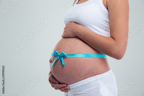 Pregnant woman with gift ribbon on belly