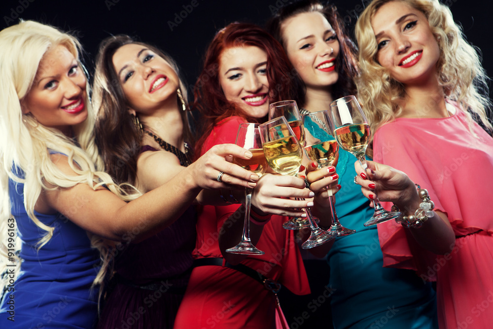 partying girls clinking flutes with sparkling wine