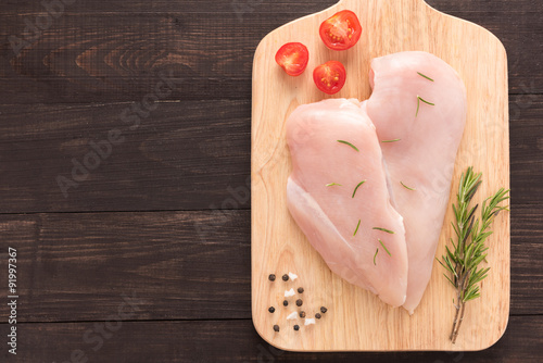 Top view raw chicken breast on wooden background