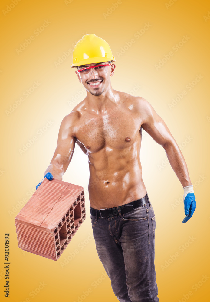 Muscular builder with bricks on white Muscular builder with bricks on white