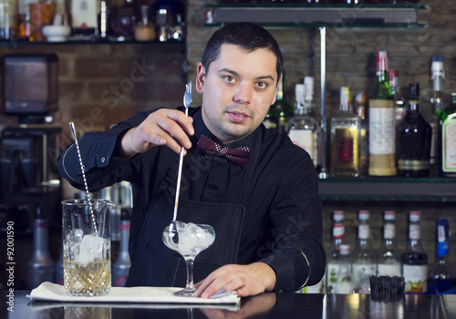 young man working as a bartender in a nightclub bar