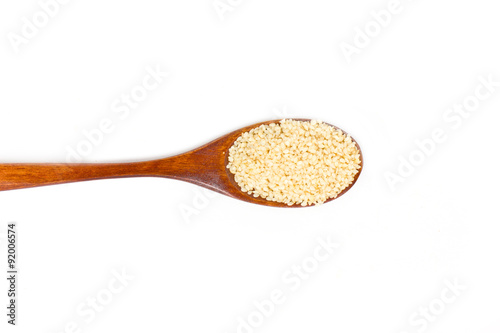 Sesame seeds on wooden spoon isolated on white background.