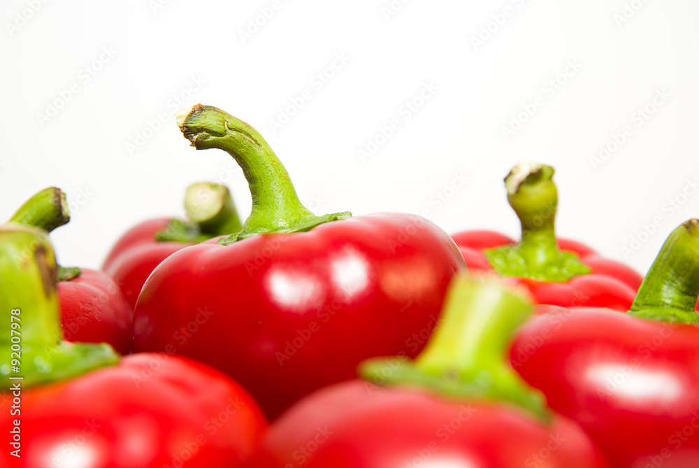 Many ripe red peppers on over white Many ripe red peppers on over white