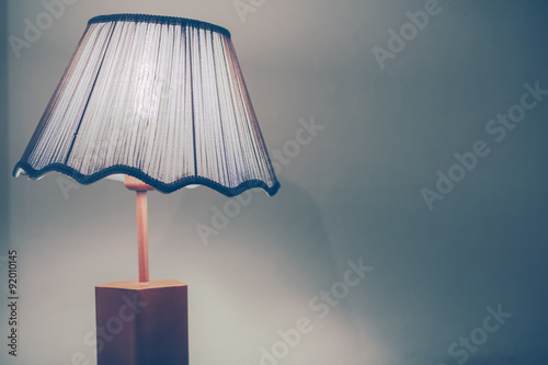 Vintage style bed lamp with green wall in cross process with blue tone.