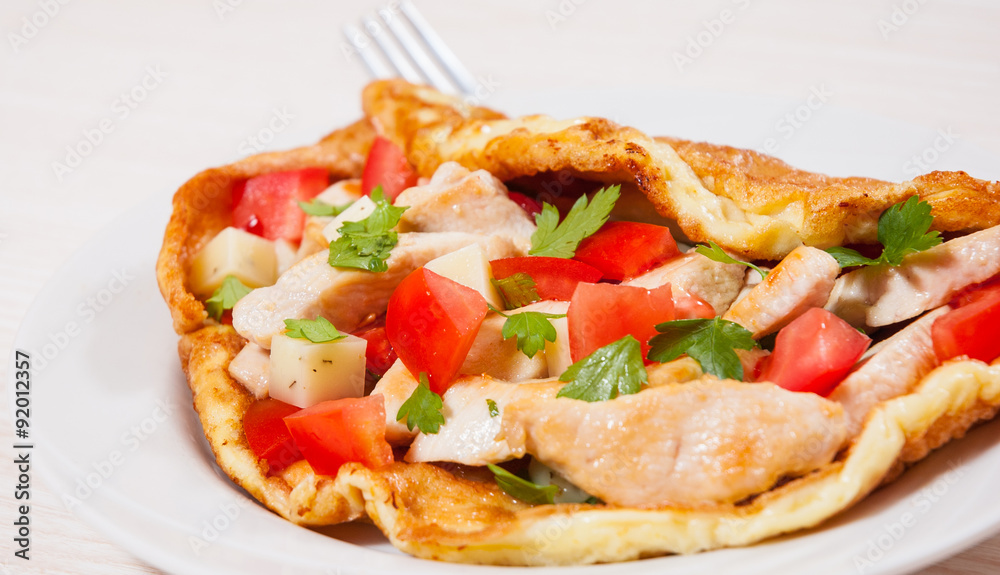 omelette with slices of chicken breast, cheese and vegetables