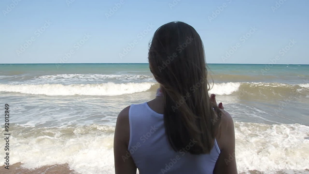 lonely young woman looking at the sea lonely young woman looking at the sea