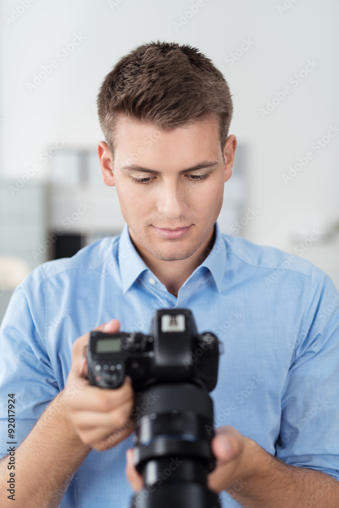 mann im fotostudio schaut auf seine digitalkamera