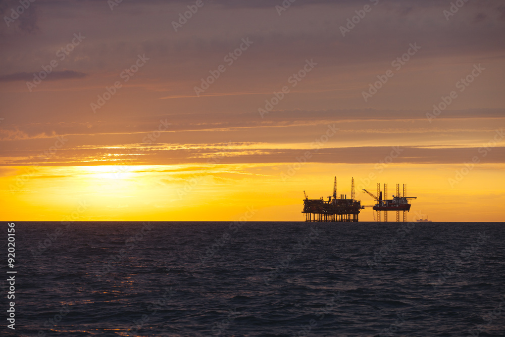 Silhouette of oil platform at sunset