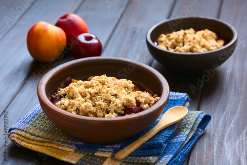 Принти на полотні Two rustic bowls filled with baked plum and nectarine crumble or crisp, photogra