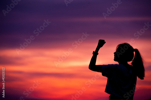 silhouette of Successful woman with arm up.