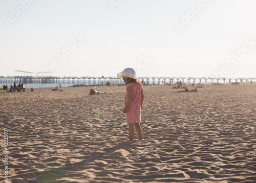 Little girl walking on the beach photo