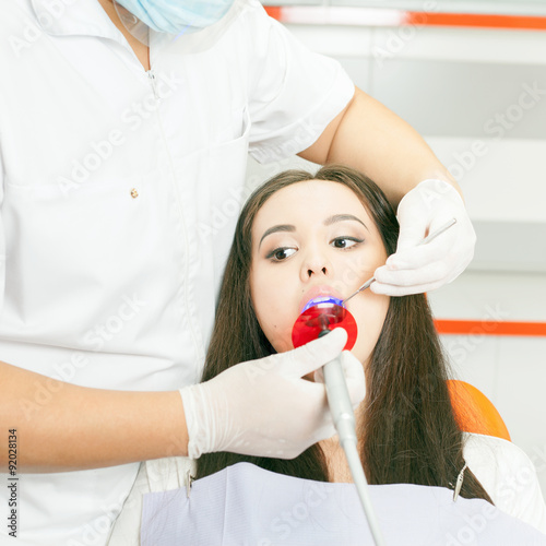 Dentist doctor treats teeth patient girl in dental office