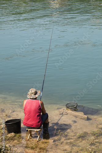 Fisherman sitting on a chair in the river