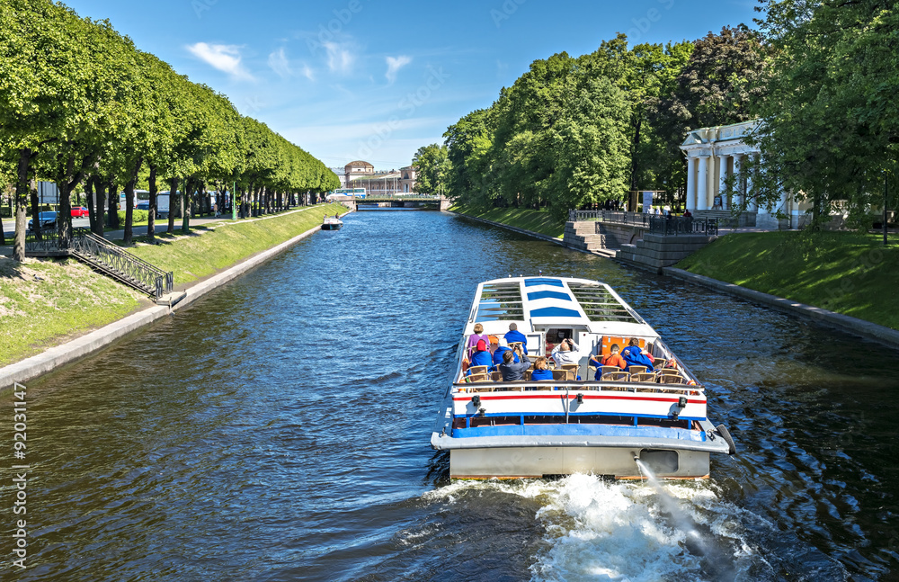 Naklejka premium Pleasure boat in a canal of Sankt Petersburg, Russia
