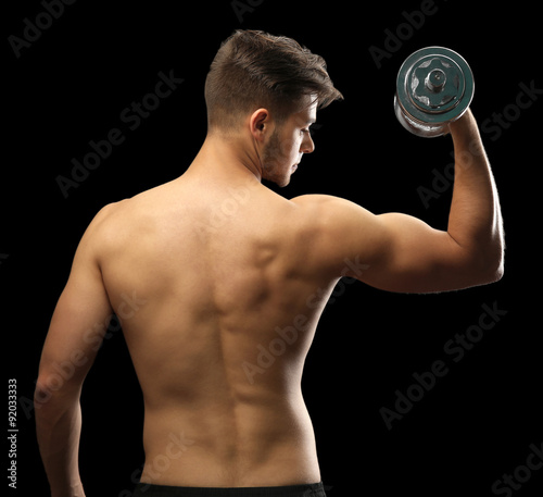 Muscle young man holding du...