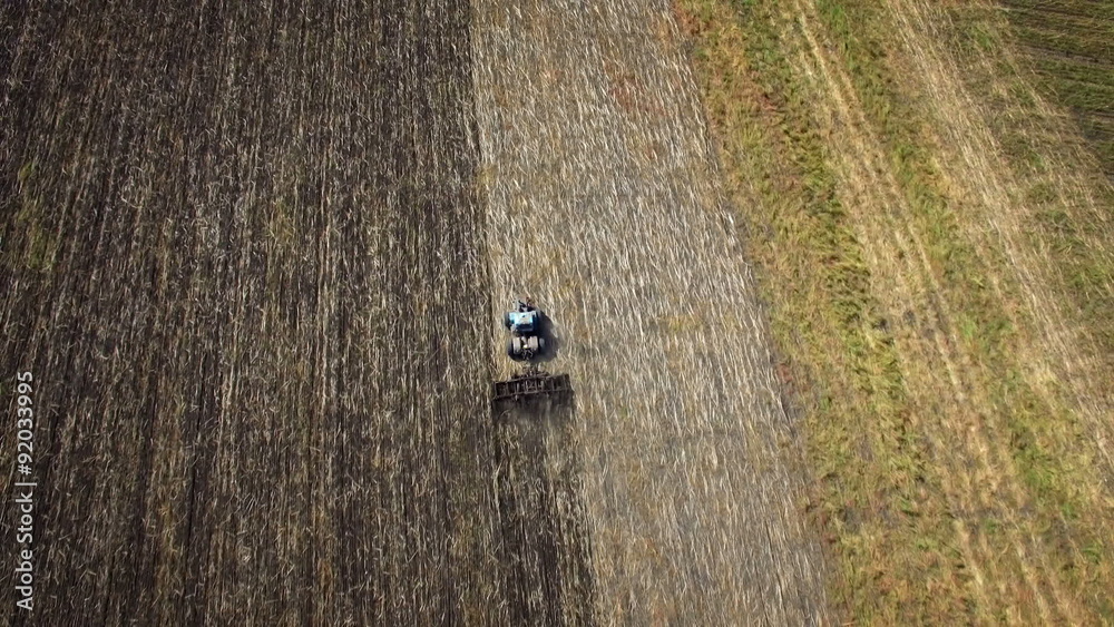 Aerial: Tractor plowing the soil. Top view. Aerial: Tractor plowing the soil. Top view.