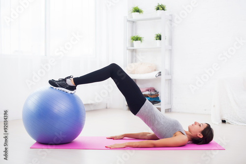 sporty woman doing pilates exercise lifting her pelvis with fit