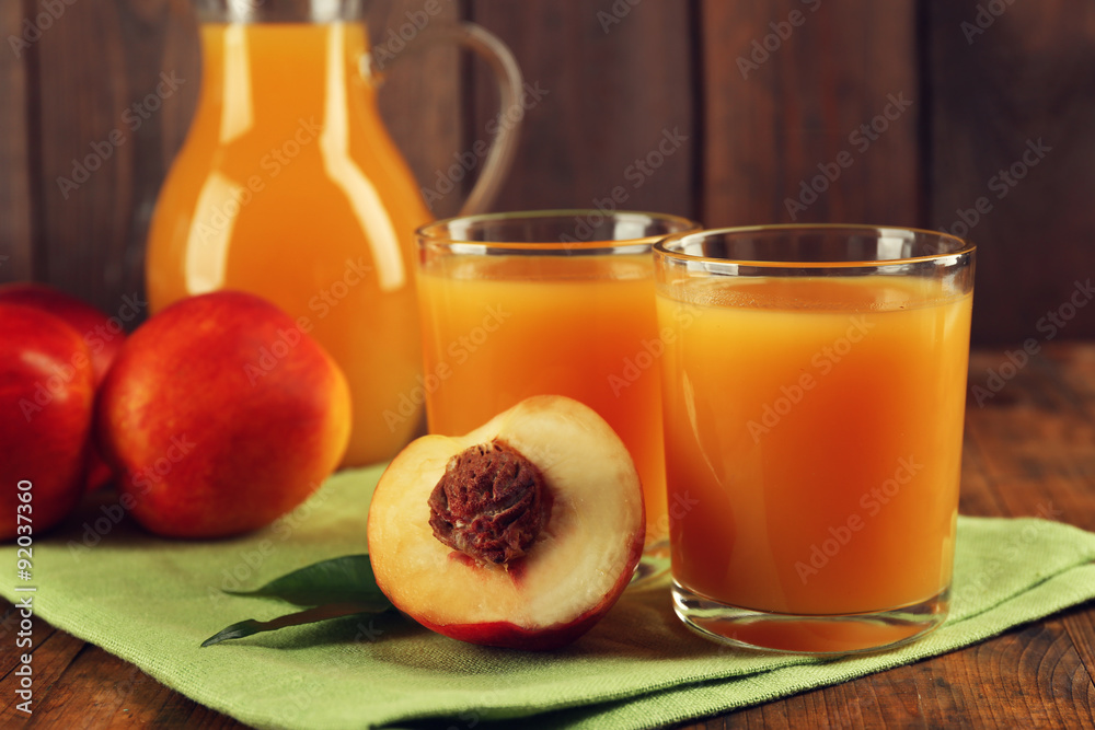Peach juice and ripe peaches on wooden background Peach juice and ripe peaches on wooden background