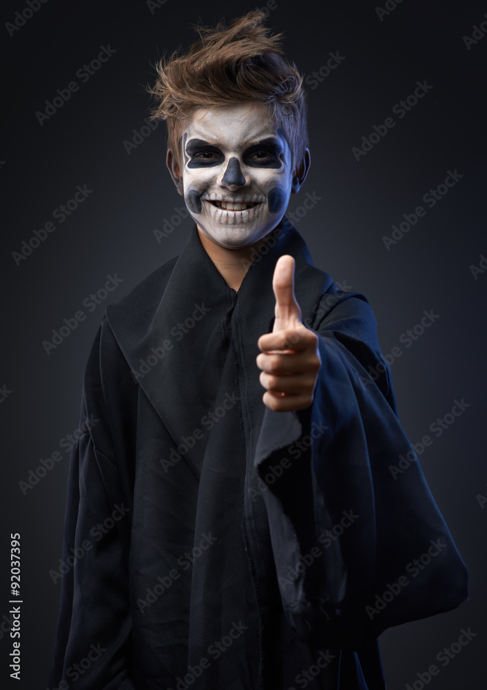 Teen with makeup skull showing thumbs up Teen with makeup skull showing thumbs up