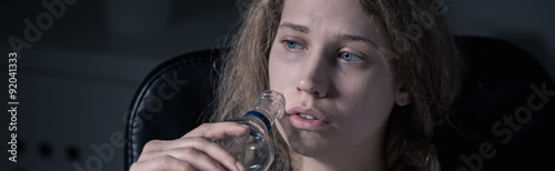 Bilde på lerret Woman drinking vodka from bottle