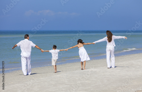 Mother, Father and Children Family Walking on Beach