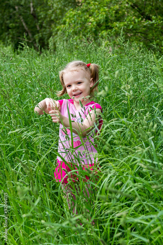 little girl with pigtails in tall grass