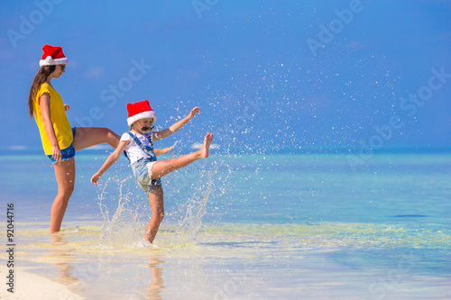 Little girl and young mother in Santa Hat during beach vacation © travnikovstudio