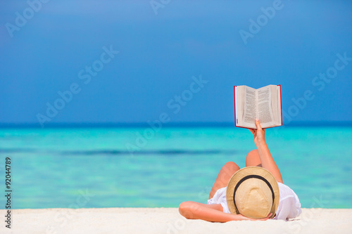Εκτύπωση καμβά Happy girl reading during tropical white beach