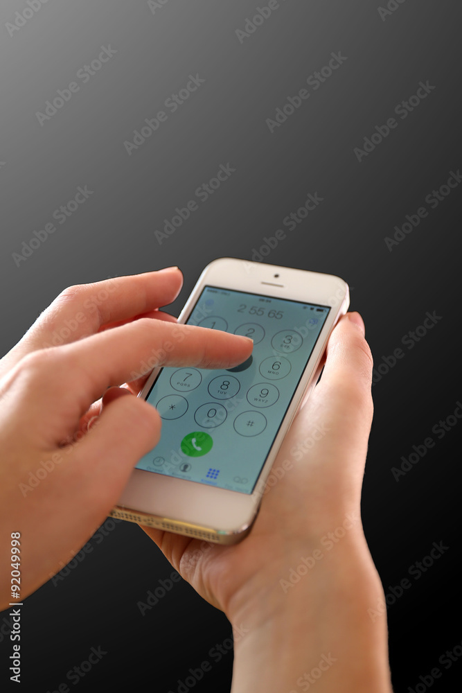 Finger touch number on smartphone to make a call on black background Finger touch number on smartphone to make a call on black background