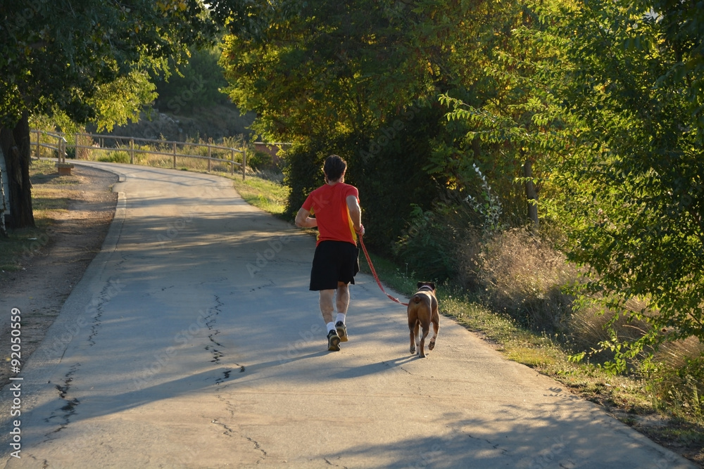 corriendo con su perro por el campo