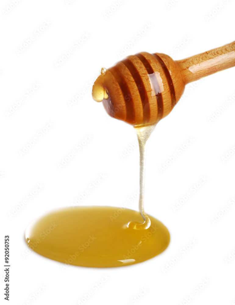 Honey dripping from dipper on light surface Honey dripping from dipper on light surface