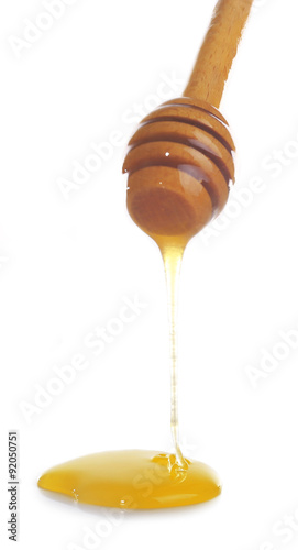 Honey dripping from dipper isolated on white