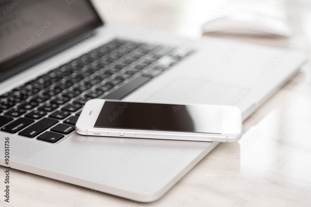 laptop with smart phone on table laptop with smart phone on table