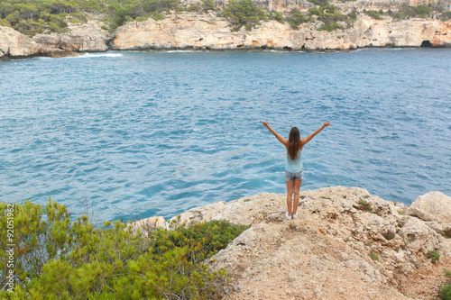 Happy free teenager raising arms on vacations