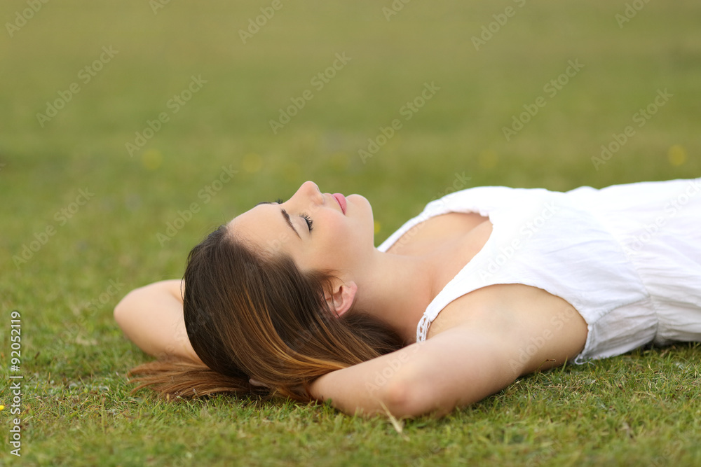 Relaxed woman lying on the grass sleeping in a tranquil scene Relaxed woman lying on the grass sleeping in a tranquil scene